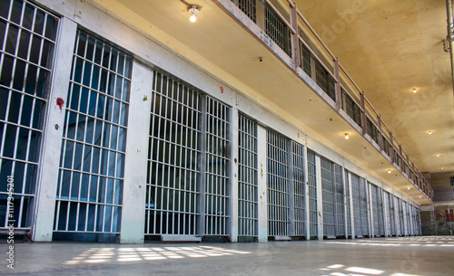 A prison cell block with many cells and bars