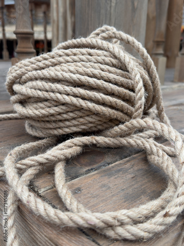 A long rope is laying on a wooden surface