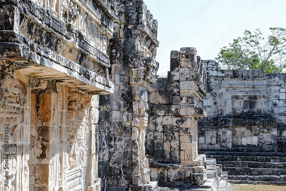 Majestic ancient ruins with intricate carvings and weathered walls invite exploration against a clear sky, showcasing the allure of a bygone era.