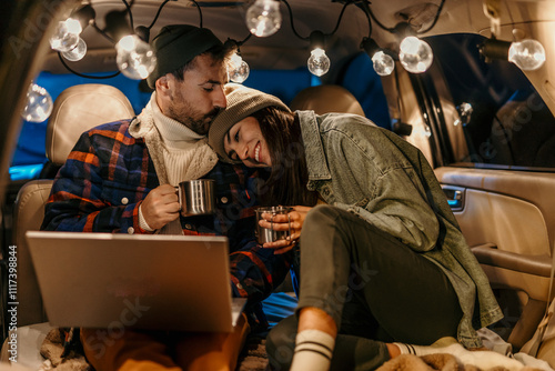Foto Cozy couple in a car trunk talking and sipping hot beverages on a chilly evening