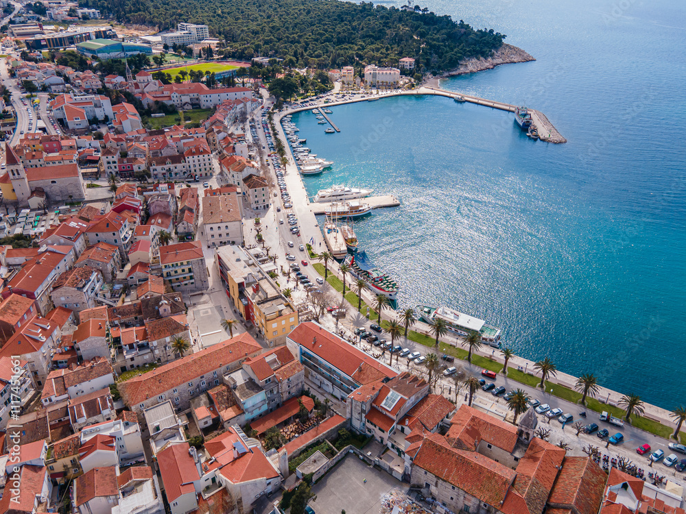 Aerial view of Makarska city center with its vibrant waterfront, yachts, traditional architecture, and the stunning Adriatic Sea coastline Aerial view of Makarska city center with its vibrant waterfront, yachts, traditional architecture, and the stunning Adriatic Sea coastline