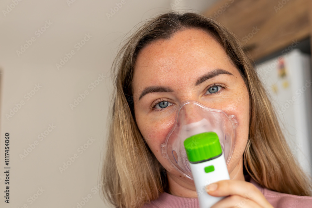 Woman using a nebulizer at home for respiratory therapy in a cozy indoor setting Woman using a nebulizer at home for respiratory therapy in a cozy indoor setting