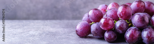 pile of deep purple grapes with glossy finish on textured surface photo