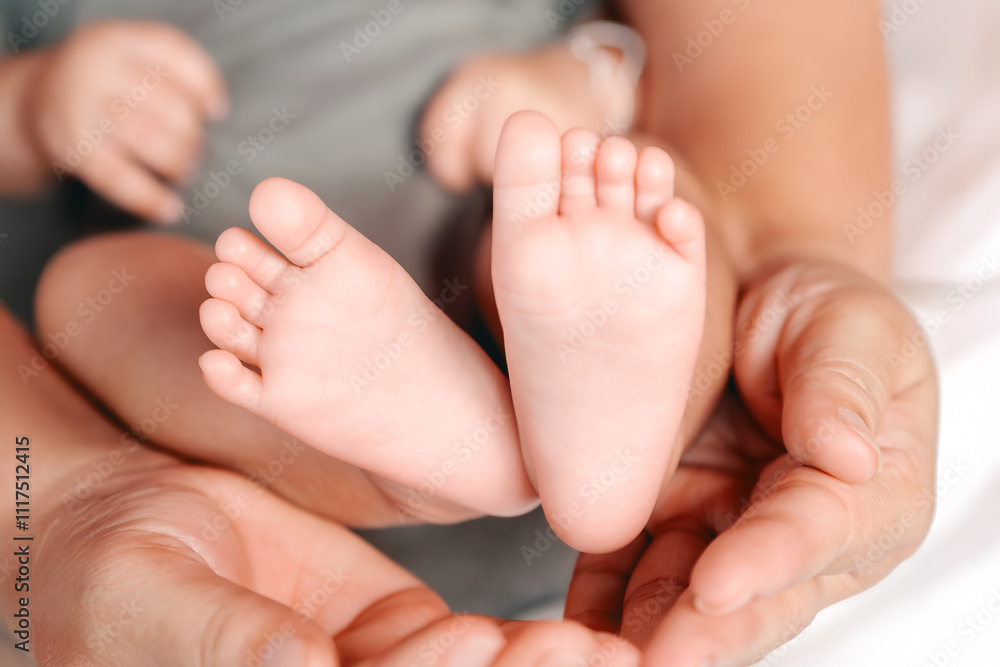 A baby's foot is held in a mother's hand. The baby is small and the mother is holding it gently. A baby's foot is held in a mother's hand. The baby is small and the mother is holding it gently.