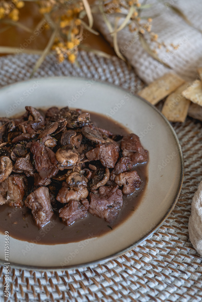 plate of meat with wine sauce on a wooden table in a house plate of meat with wine sauce on a wooden table in a house