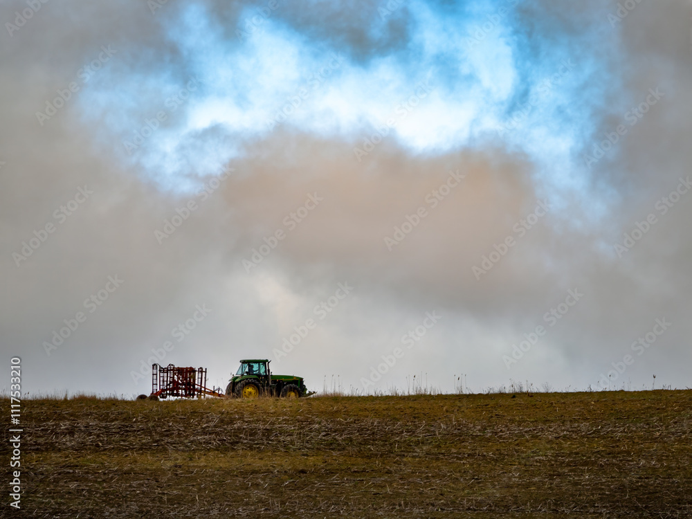 Fototapeta premium Tractor plows ground in big drought, very dry land, spring on the farm
