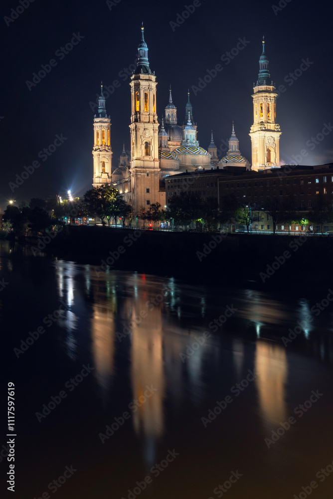 Naklejka premium Illuminated Basilica of Our Lady of the Pillar and Puente de Piedra at Night