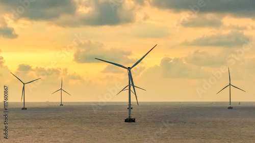 Tall windmill turbines against a clear blue sky, generating renewable energy in the serene Go Cong, Vietnam landscape by the sea. Like windmill park Westermeerdijk in the Noordoostpolder Netherlands