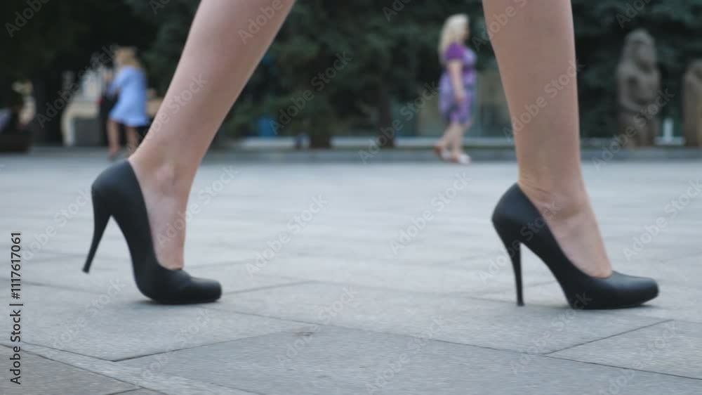 Feet of young business woman in high-heeled footwear going in the city. Female legs in high heels shoes walking in the urban street. Girl stepping to work. Slow motion Close up Feet of young business woman in high-heeled footwear going in the city. Female legs in high heels shoes walking in the urban street. Girl stepping to work. Slow motion Close up