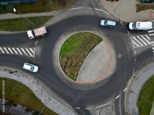 roundabout of gray granite cubes closer to the center. beveled concrete curbs with flowers and grass in the middle of the circle. half of the circle is passable through for firefighters photo