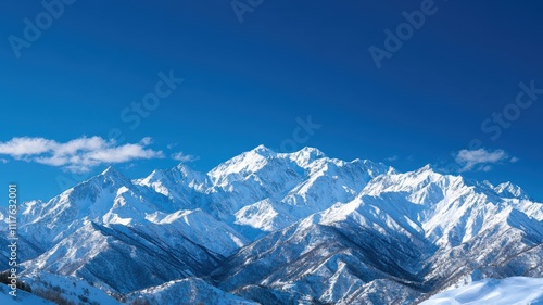 Snow-capped mountains under a clear blue sky, showcasing breathtaking natural beauty and majestic peaks.