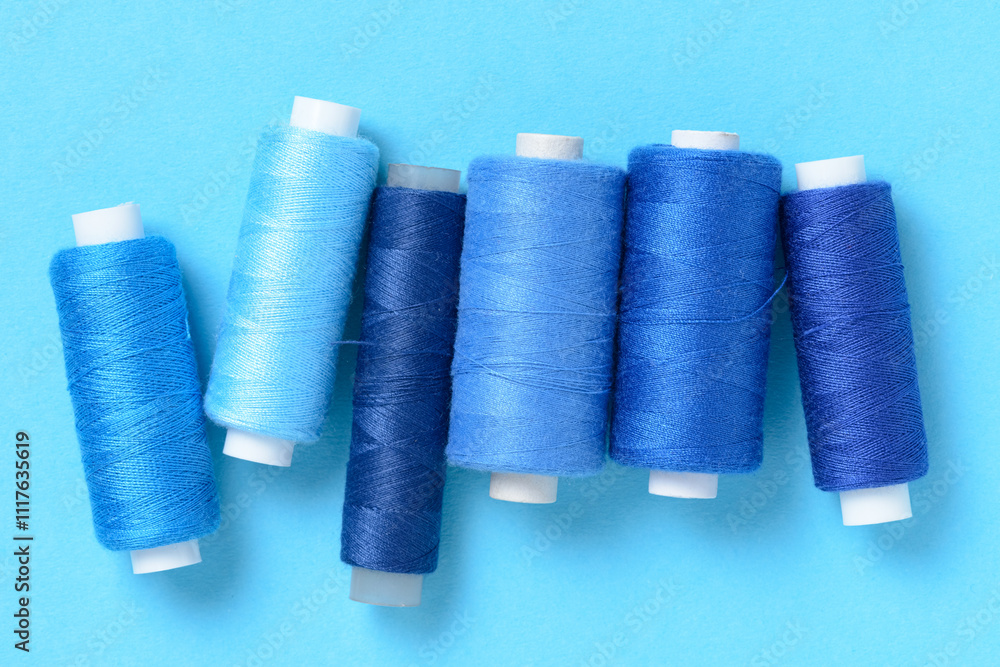 Blue thread spools background with copy space for text close-up flat lay top view Blue thread spools background with copy space for text close-up flat lay top view
