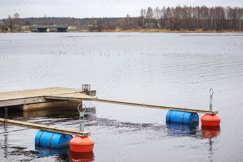 A boat dock with a boardwalk and buoys on the water photo