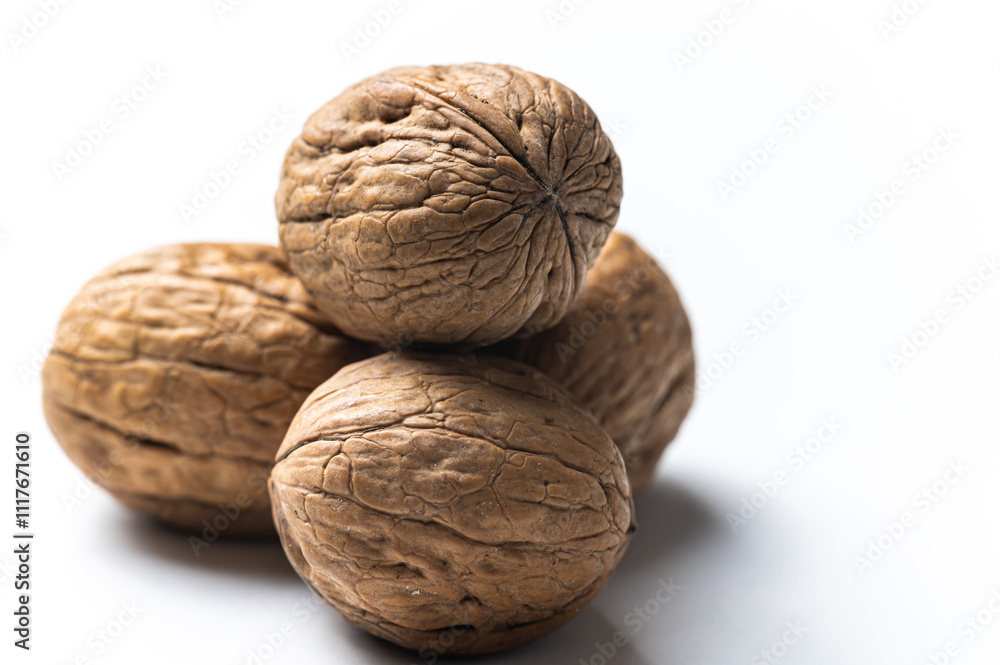 Whole walnut, photographed close up, on white surface.
Whole walnut, photographed close up, on white surface.