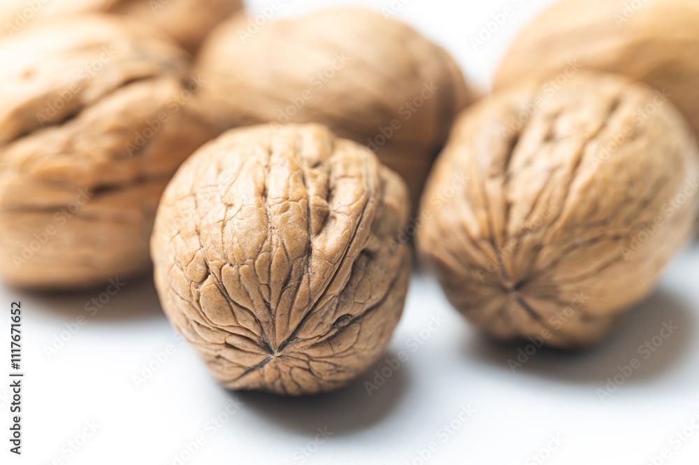 Whole walnut, photographed close up, on white surface.
Whole walnut, photographed close up, on white surface.
