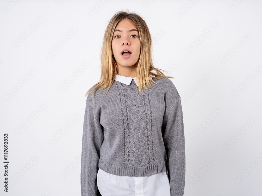 Shocked Beautiful teenager girl wearing sweater over dress shirt stares bugged eyes keeps mouth opened has surprised expression. Omg concept Shocked Beautiful teenager girl wearing sweater over dress shirt stares bugged eyes keeps mouth opened has surprised expression. Omg concept