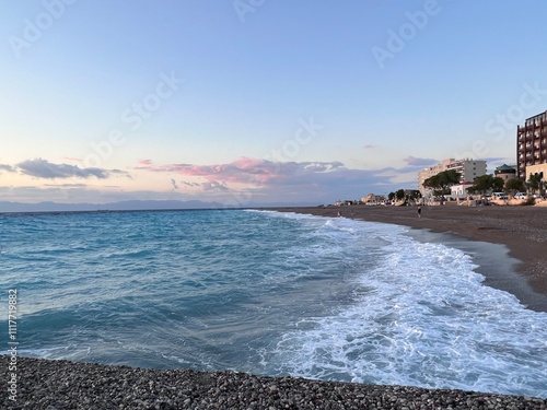 Crystal clear turquoise water in a Glystra beach. Cane umbrellas and sunbeds on an beach resort - vacation concept on Greece islands in Aegean and Mediterranean sea. Near Lindos at east Rhodes. Greece photo