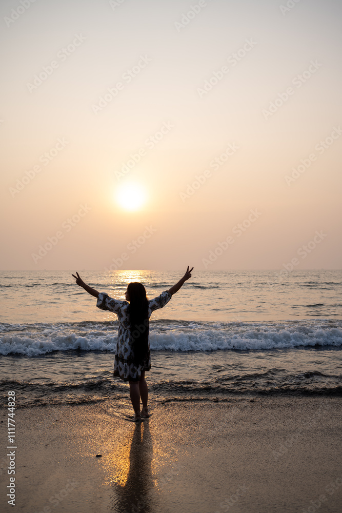 Fototapeta premium strong confidence woman open arms under the sunrise or sunset at seaside