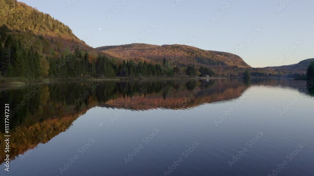 A picturesque scene of a serene lake reflecting forested hills under a clear evening sky. The still water and natural beauty create a peaceful, untouched wilderness ambiance. A picturesque scene of a serene lake reflecting forested hills under a clear evening sky. The still water and natural beauty create a peaceful, untouched wilderness ambiance.