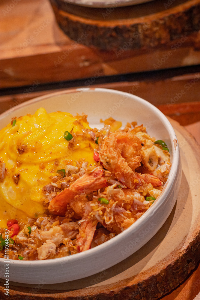 High angle, Creamy omelet with deep-fried seafood, chili and salt served with rice on dish, place on wooden board High angle, Creamy omelet with deep-fried seafood, chili and salt served with rice on dish, place on wooden board