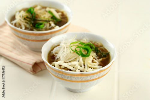 Soto CAam Mangkok Cilik. Soto is Traditional Indonesian Spice Soup with Chicken, Noodlea, and Sliced Cabbage. Served on Small Bowl photo