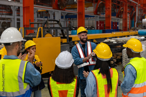 A young foreman gives instruction and job description for the day to his mechanical engineer team next to the iron steel machine. Cooperation among factory workers. Safety brief before the day starts