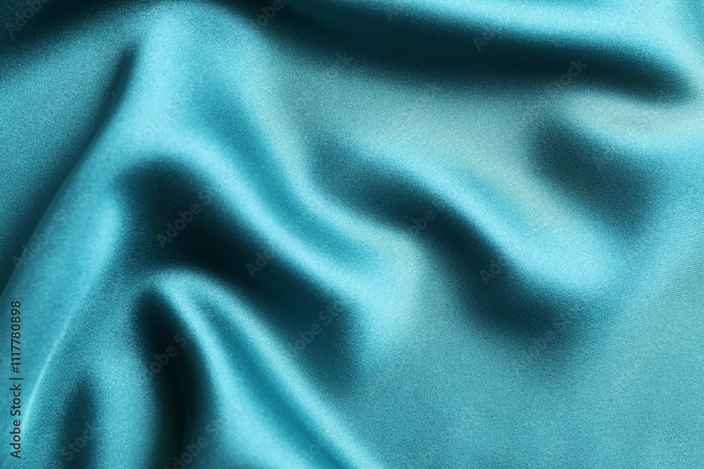 Fototapeta premium Silk satin dark turquoise color. Shiny smooth fabric. Soft folds. Luxury background with space for design. Flat table, top view