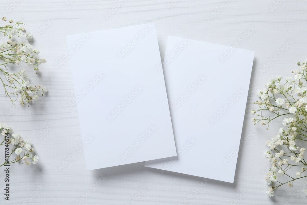 Top view photo with gypsophila flowers and paper cards on white background Top view photo with gypsophila flowers and paper cards on white background