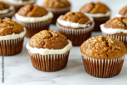 Freshly baked muffins topped with creamy frosting on a wooden table