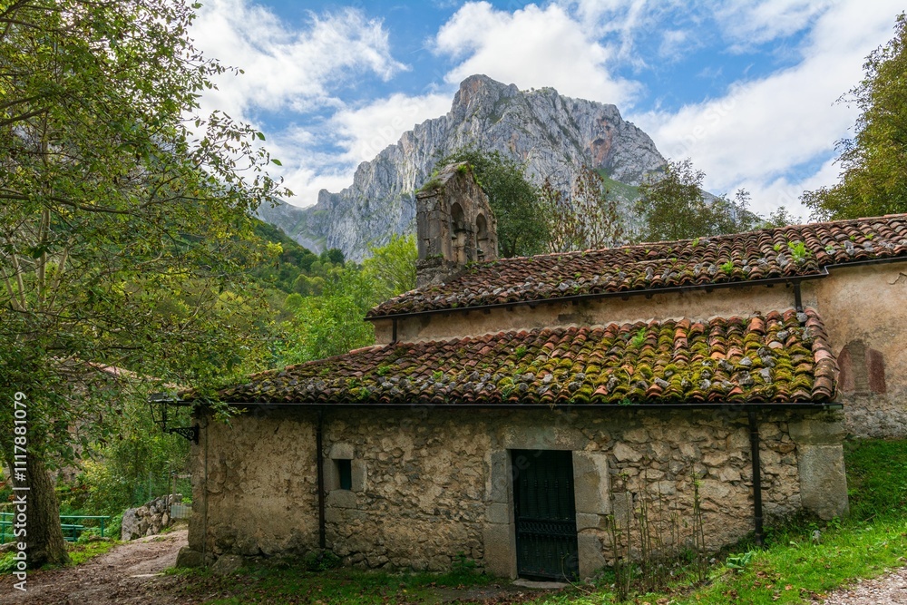 Rustic stone building and mountain backdrop