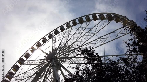 Budapest Ferris wheel spinning at twilight, framed by city lights and an evening sky, motion lapse with clouds in sky above photo