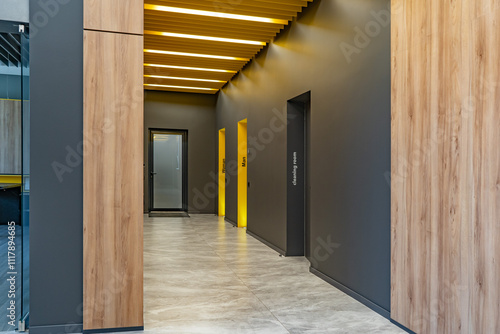 Perspective of a long corridor in office building. Doors of washrooms in hallway. Doors in office with wc signs. Entrance to restrooms in a factory