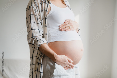 Pregnant woman holds hands on belly. Pregnancy, maternity concept. photo