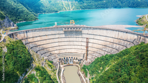 Aerial view of Enguri Dam, large hydroelectric dam with turquoise reservoir, nestled amidst lush green hills.  photo