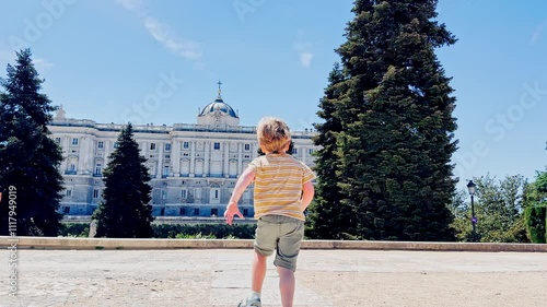 Boy, happy tourist races with joy to large Royal palace