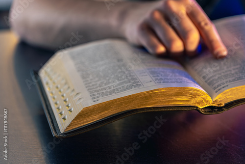 A man reads the Bible. Male hands on the Holy Bible. Close-up of the Bible.