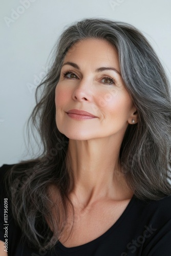 An older woman with gray hair poses for a portrait, exuding a sense of calm and contemplation.