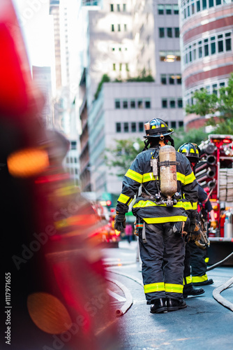 Brave Firefighters in Full Gear Battling an Urban Emergency in the Heart of a Vibrant City Center, Highlighting Teamwork and Courage in Modern Skyscraper Environment