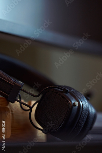 Stylish black headphones resting on a wooden desk