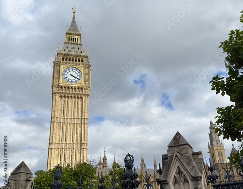 Big Ben towering above the houses of parliament against a cloudy sky in Westminster, London, UK.  photo