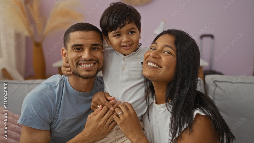 Happy family with man, woman, and child smiling together in the living room of their cozy home Happy family with man, woman, and child smiling together in the living room of their cozy home