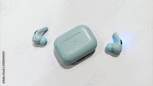 Wireless AirPods Bluetooth headphones and charging box for smartphone. Earpods Airpods or new earphones in box on white background. Selective focus photo