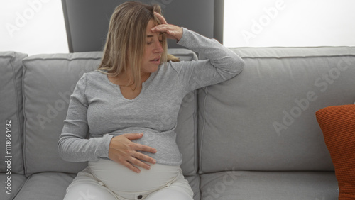 Pregnant woman relaxing on a sofa in a cozy living room with a hand on her belly, wearing casual clothes, interior setting softly lit, capturing a moment of contemplation.