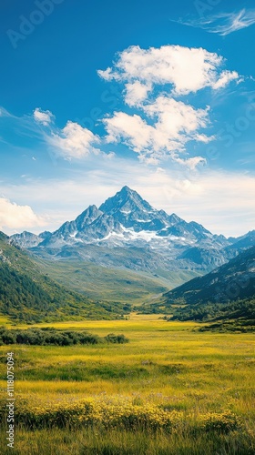 A breathtaking mountain landscape under a clear blue sky, featuring lush green fields and distant snow-capped peaks.