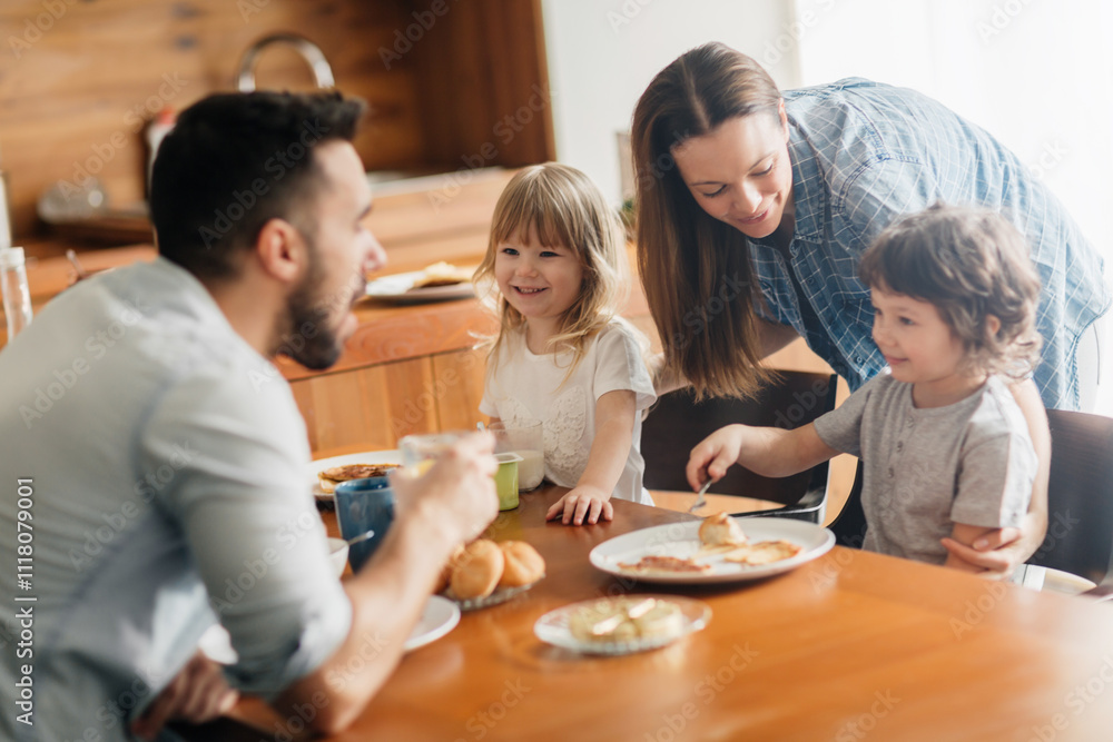 Happy family enjoying breakfast together in a cozy kitchen Happy family enjoying breakfast together in a cozy kitchen
