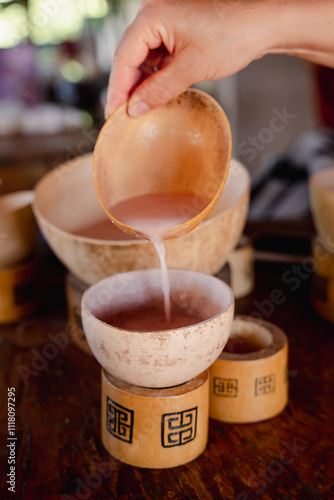 Hand pouring into a bowl the traditional drink of the indigenous people of Peru called Masato.