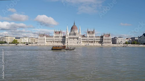View of the Hungarian Parliament Building on the bank of the Danube river in Budapest. Old cruising boat in front of Parliament Building. 