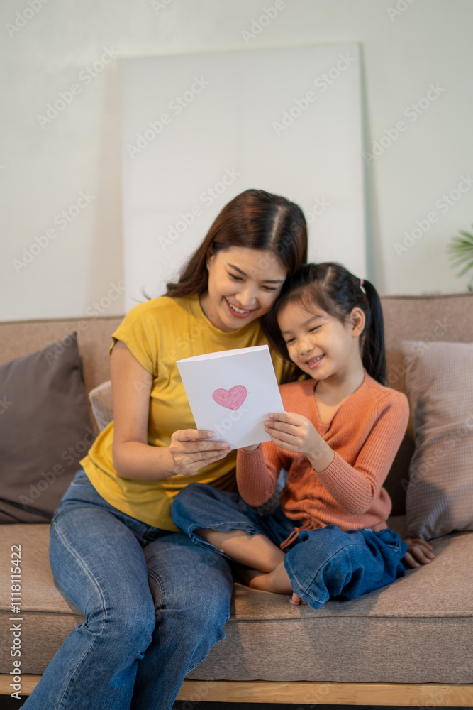 Lovely mom and little young daughter spending time together in their living room. Lovely mom and little young daughter spending time together in their living room.