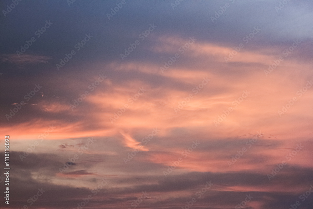 Fototapeta premium A breathtaking sunset paints the sky with vibrant hues of pink, orange, and purple. Wispy clouds drift across the canvas, creating a mesmerizing spectacle.