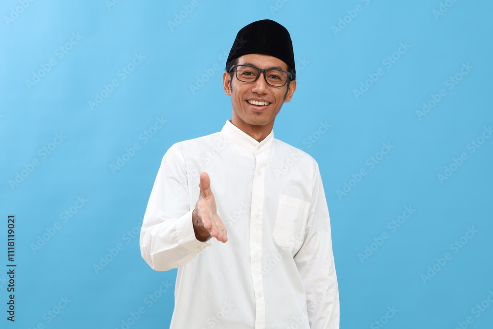 Asian muslim man over isolated background smiling friendly offering handshake as greeting and welcoming